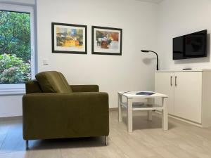 ein Wohnzimmer mit einem Stuhl und einem Tisch in der Unterkunft Haus Etzold in Norderney