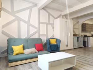 a living room with a blue couch and colorful pillows at wintzenheim: appartement in Wintzenheim