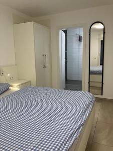 Schlafzimmer mit einem blauen und weißen Bett und einem Spiegel in der Unterkunft Haus Etzold in Norderney