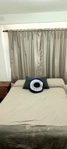 a bed with a blue and white pillow on it at Mi depa en Esquel in Esquel