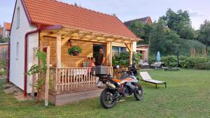 a motorcycle parked in front of a log house at Pavlov24 - Domeček u potoka in Pavlov