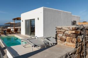 a house with a swimming pool and a stone wall at Deja blue villa 2 in Agios Georgios