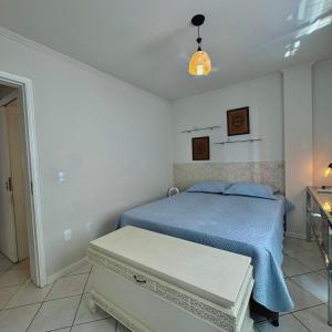 a bedroom with a bed and a table in it at Next to the sea, Central beach in Balneário Camboriú