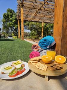 a table with two plates of food and some oranges at Bougainvillea Beach Villa in Mponda