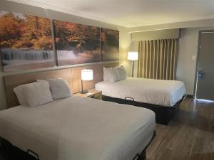 a hotel room with two beds and two lamps at Days Inn by Wyndham Wilmington Brandywine in Talleyville +18 photos