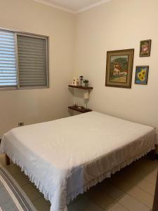 a bedroom with a large white bed in a room at Casa 50m da praia - Enseada/Guarujá in Guarujá +34 photos