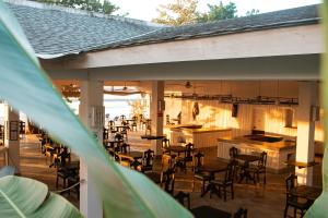 an outdoor patio with chairs and tables and a bar at Merrils Deluxe at Veraclub in Negril