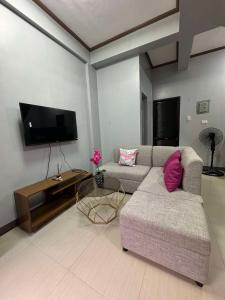 a living room with a couch and a flat screen tv at JP Suites & Residences in Tayabas