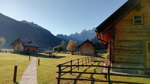a group of buildings with mountains in the background at Alpi Giulie Chalets in Valbruna