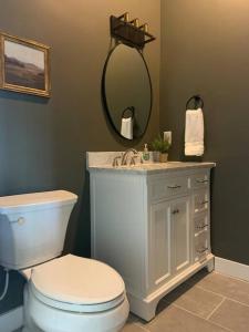 a bathroom with a toilet and a sink and a mirror at New Constructed Home in Poway in Poway