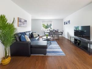 a living room with a black couch and a tv at Pet-Friendly Large 3-Bedroom - Bobcaygeon in Bobcaygeon