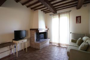 salon z kominkiem i telewizorem w obiekcie Azienda Agraria Fratelli Caporali w mieście Ponte Pattoli