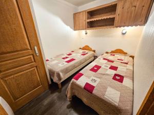 two twin beds in a small room with a cabinet at Appartement confort 5 pers. Les Menuires avec balcon, casiers à skis, 2 chambres - FR-1-452-248 in Les Menuires