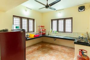 a kitchen with black counters and a ceiling fan at Be My Guest in Kozhikode