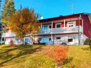 a red and white house with a tree in front of it at Rantala talo Keitele järven rannalla in Kymönkoski