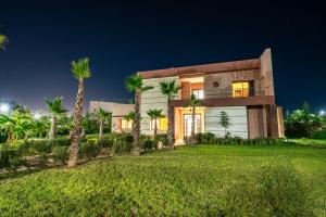 a large house with palm trees in front of it at Konouz Palace in Marrakech