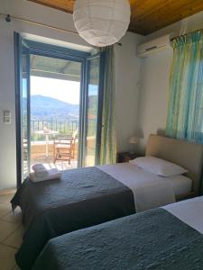 a bedroom with two beds and a balcony with a view at Casa Serenata in Pinakokhórion