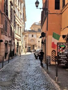 a man walking down a cobblestone street at In Ancient Rome Apartment in Rome