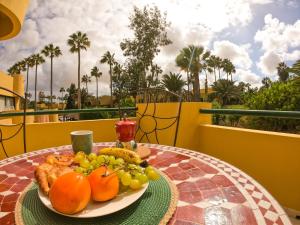 a plate of fruit on a table on a balcony at Drago 1 Atlantic Garden apartment in Corralejo