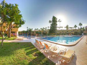a pool at a resort with chairs and a slide at Drago 1 Atlantic Garden apartment in Corralejo