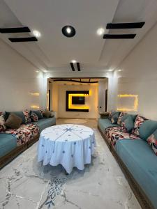 穆罕默迪耶Appartement corniche d'or, Mohammedia的客厅配有白色的桌子和沙发