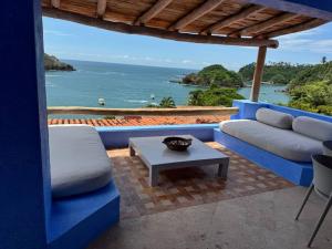 a living room with a blue couch and a table at Casita Hermanitas - 3 bedroom panoramic ocean views with private cook in Careyes