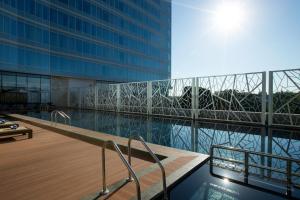 a large building with a swimming pool and a building at Novotel Makassar Grand Shayla in Makassar