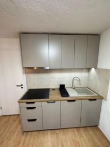 a kitchen with white cabinets and a sink at Studio apartment Lovrekovic in Zagreb