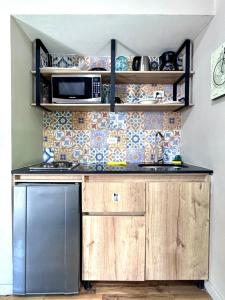 una cocina con estufa y microondas en Alojamiento que permite mascota en Medellín A103 By Roots Rentals, en Medellín 11 fotos más