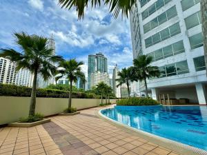 a swimming pool in the middle of a building with palm trees at Hushed Dorm KL in Kuala Lumpur