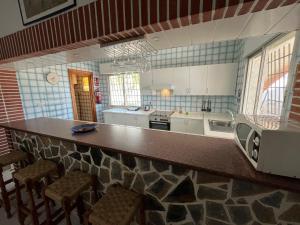 a kitchen with a counter with chairs and a microwave at Villa Garruchal in El Caracolero