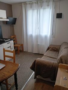 a living room with a bed and a window at Évasion Hébergement in Allevard