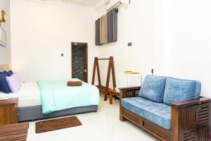a bedroom with a bed and a blue couch at Surf Lavender in Weligama