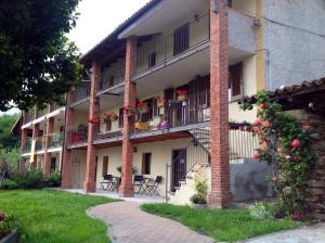 un immeuble d'appartements avec balcon, tables et chaises dans l'établissement Cascina Brunod, à Chiaverano