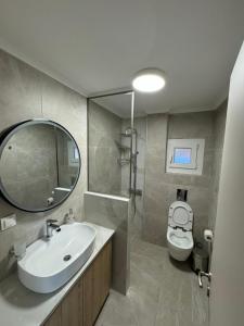 a bathroom with a sink and a toilet and a mirror at Luxurious Modern Villa in Pefkohori +22 photos