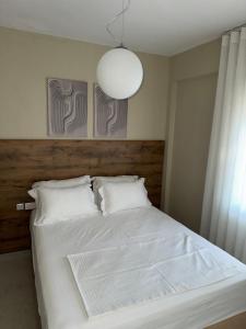 a bedroom with a bed with white sheets and a lamp at Luxurious Modern Villa in Pefkohori