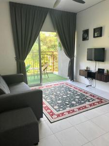 a living room with a couch and a sliding glass door at Ammara Homestay 2 Emerald Avenue Brinchang in Brinchang