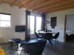 a living room with a table and chairs at De Heide in Wijnjewoude