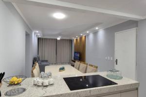 a kitchen with a sink and a living room at AP DA PAZ - Praia do Forte - Cabo Frio in Cabo Frio