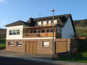 a large brick house with a balcony on top of it at Pension Kroth an der Mosel in Briedel