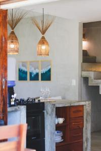 a kitchen with two pendant lights and a counter at Casa Devagar Icaraizinho in Amontada +43 photos