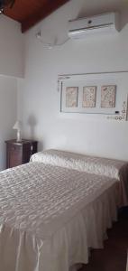 Un dormitorio con una cama con un edredón blanco. en Casa Brito, en Monte Hermoso
