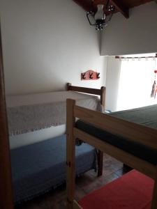 Un dormitorio con dos literas y una ventana. en Casa Brito, en Monte Hermoso 6 fotos más