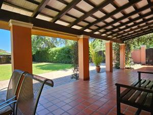 a patio with two chairs and a wooden pergola at Villa Arbolada in San Lorenzo