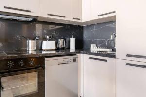 a kitchen with white cabinets and a stove at Luxury 105 Studio in Casablanca +8 photos
