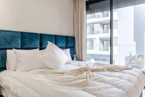 a large white bed with a blue headboard and a window at Luxury 105 Studio in Casablanca