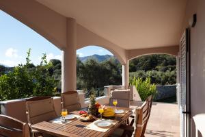 a table and chairs on a patio with a view at Villa Amalia in Áyios Vasílios