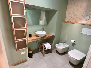 a bathroom with a sink and a toilet and a mirror at B&Bike la vetrata sui vigneti in Stazione di Bornato-Calino