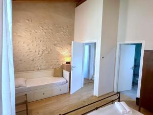 a room with a couch and two open doors at B&Bike la vetrata sui vigneti in Stazione di Bornato-Calino
