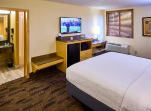 a hotel room with a bed and a flat screen tv at LivINN Hotel Minneapolis South / Burnsville in Burnsville
